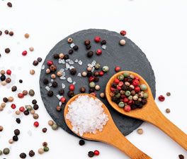 Peppercorns and salt in spoons